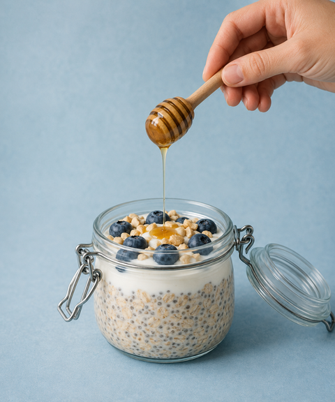 Overnight-Müsli im Glas mit Blaubeeren, Chiasamen, gehackten Cashews und griechischem Pinienhonig